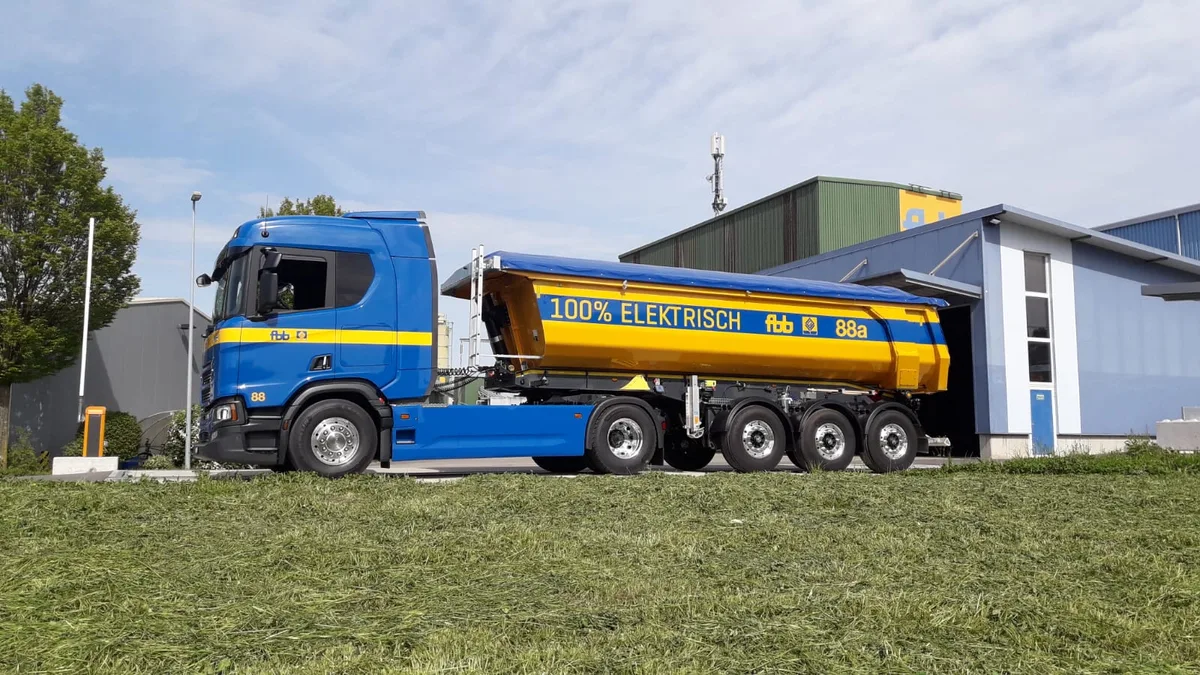 Aus mehr als 100 Lkw besteht die Flotte von FBB. Seit Sommer hat der Baustoffproduzent zwei batterieelektrisch betriebene Scania-Lkw im Einsatz. Ein in den Farben Blau und Gelb gehaltener Sattelschlepper der Firma FBB von Scania. Das Fahrzeug fährt batterieelektrisch.
